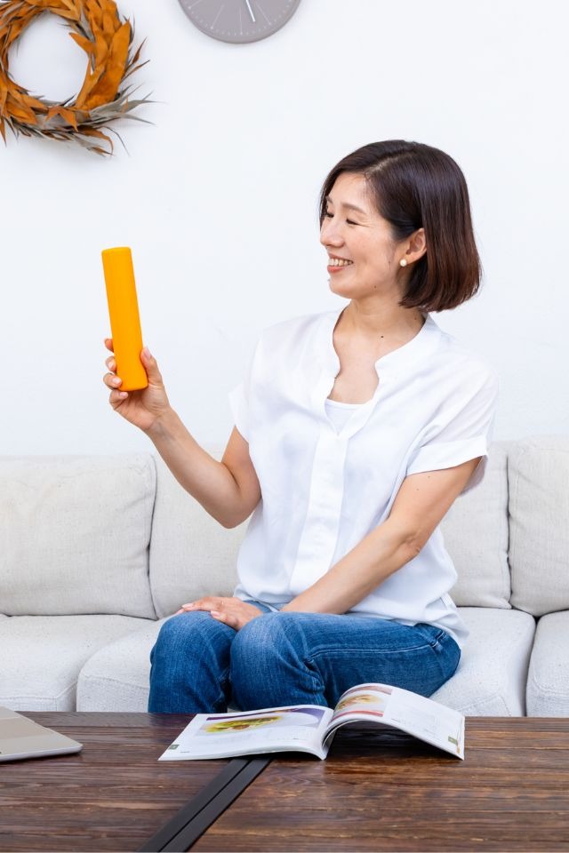 スマートフォンを見るリビングの女性